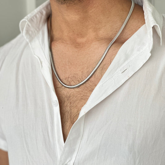 Man wearing a white shirt with a silver necklace